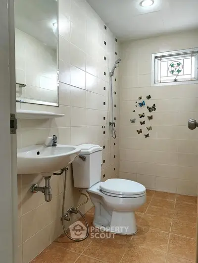 Modern bathroom with tiled walls, shower, and butterfly decor