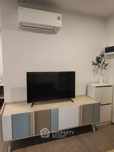 Modern living room with sleek TV stand and air conditioning unit, perfect for comfortable living.
