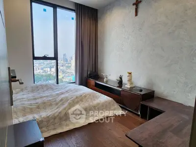 Modern bedroom with city view, wooden flooring, and stylish decor in high-rise apartment.