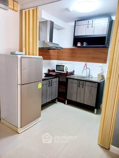 Modern kitchen with sleek cabinets and stainless steel appliances in a cozy apartment.