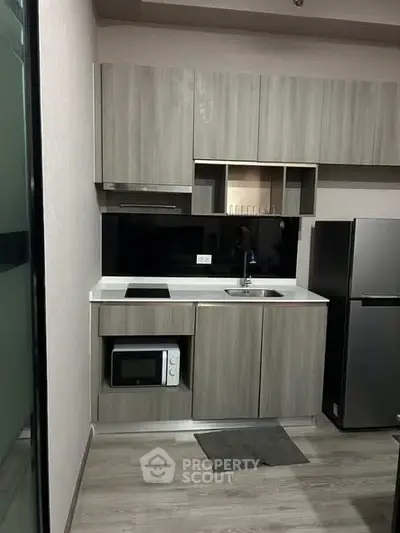 Modern compact kitchen with sleek cabinetry and built-in appliances, perfect for urban living.