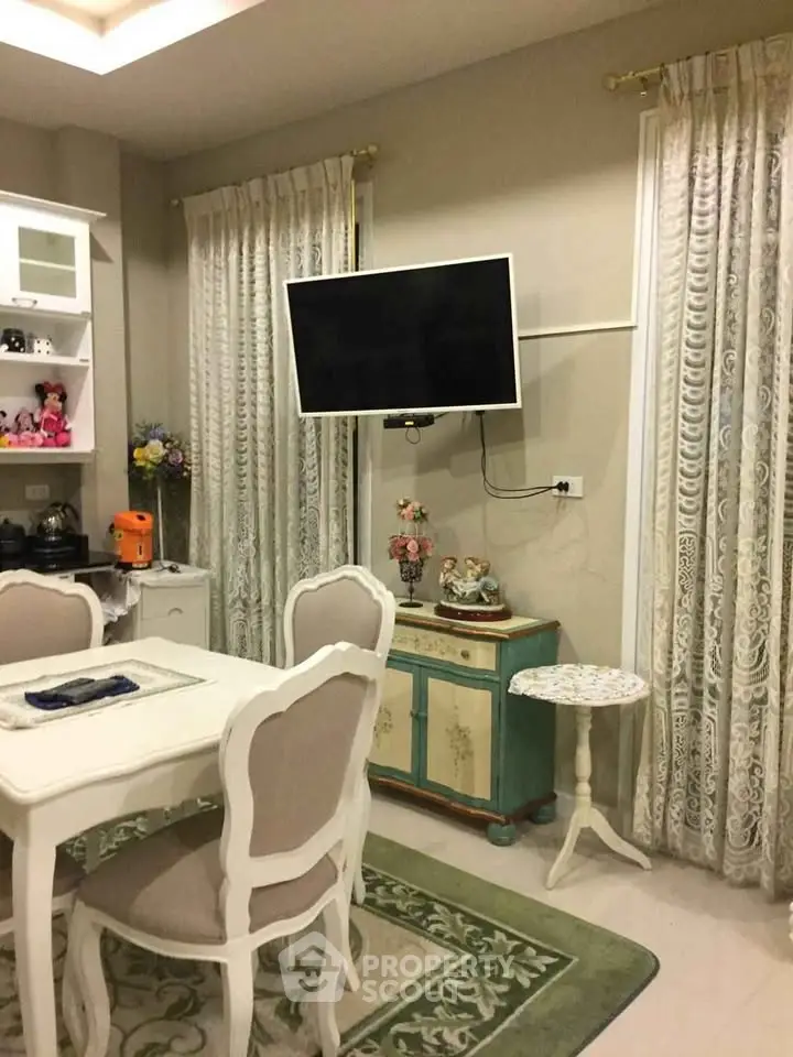 Charming living room with elegant dining set and wall-mounted TV, perfect for cozy gatherings.