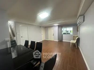 Spacious living room with modern dining area and wooden flooring