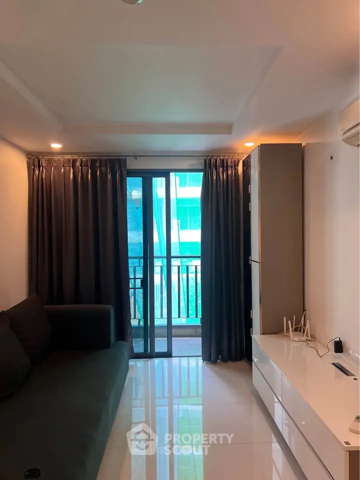Modern living room with sleek furniture and balcony view in a stylish apartment.
