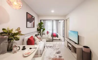 Modern living room with stylish decor and open view to bedroom, featuring cozy seating and elegant dining area.