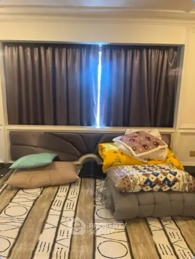Cozy bedroom with plush bedding and elegant curtains in a stylish home.