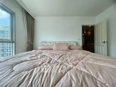 Cozy bedroom with large window and plush bedding in modern apartment
