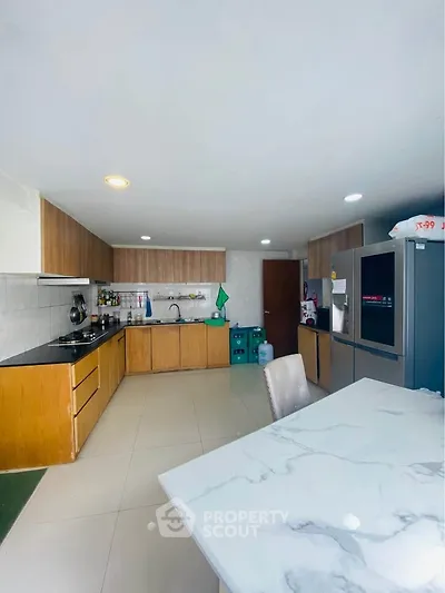 Spacious modern kitchen with sleek cabinetry and marble dining table