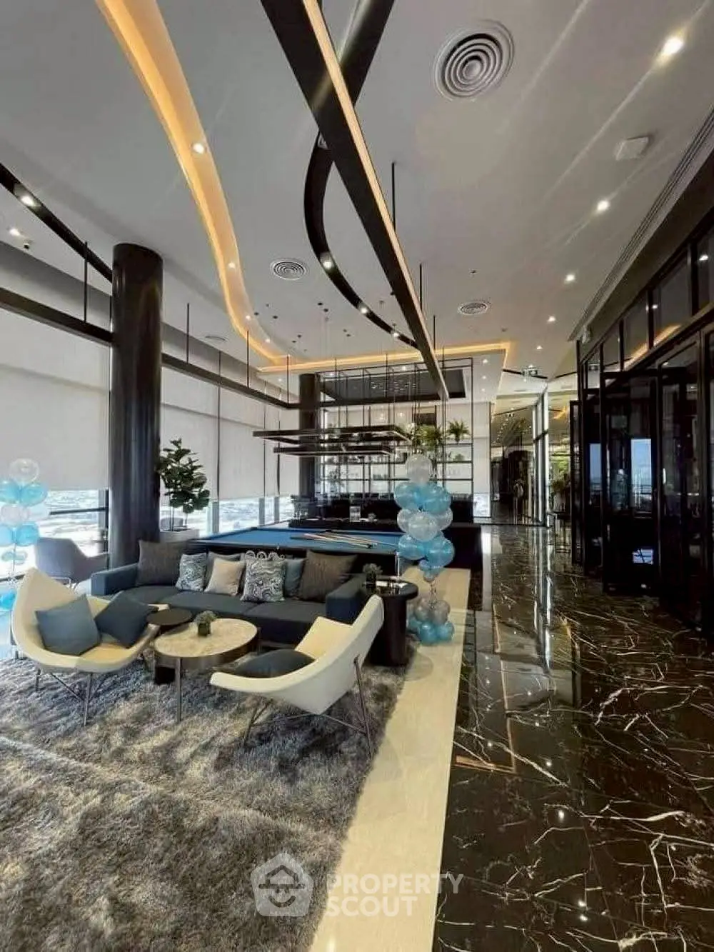 Luxurious modern lobby with elegant seating and marble flooring in upscale building.