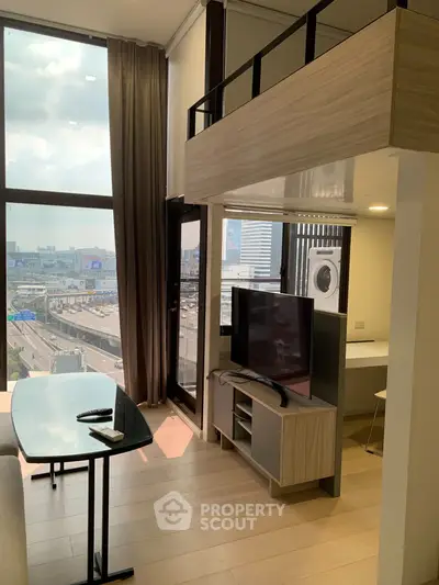 Modern loft apartment with floor-to-ceiling windows and city view, featuring a cozy living area and stylish decor.