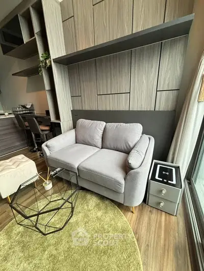 Modern living room with stylish gray sofa, geometric coffee table, and elegant wood paneling.