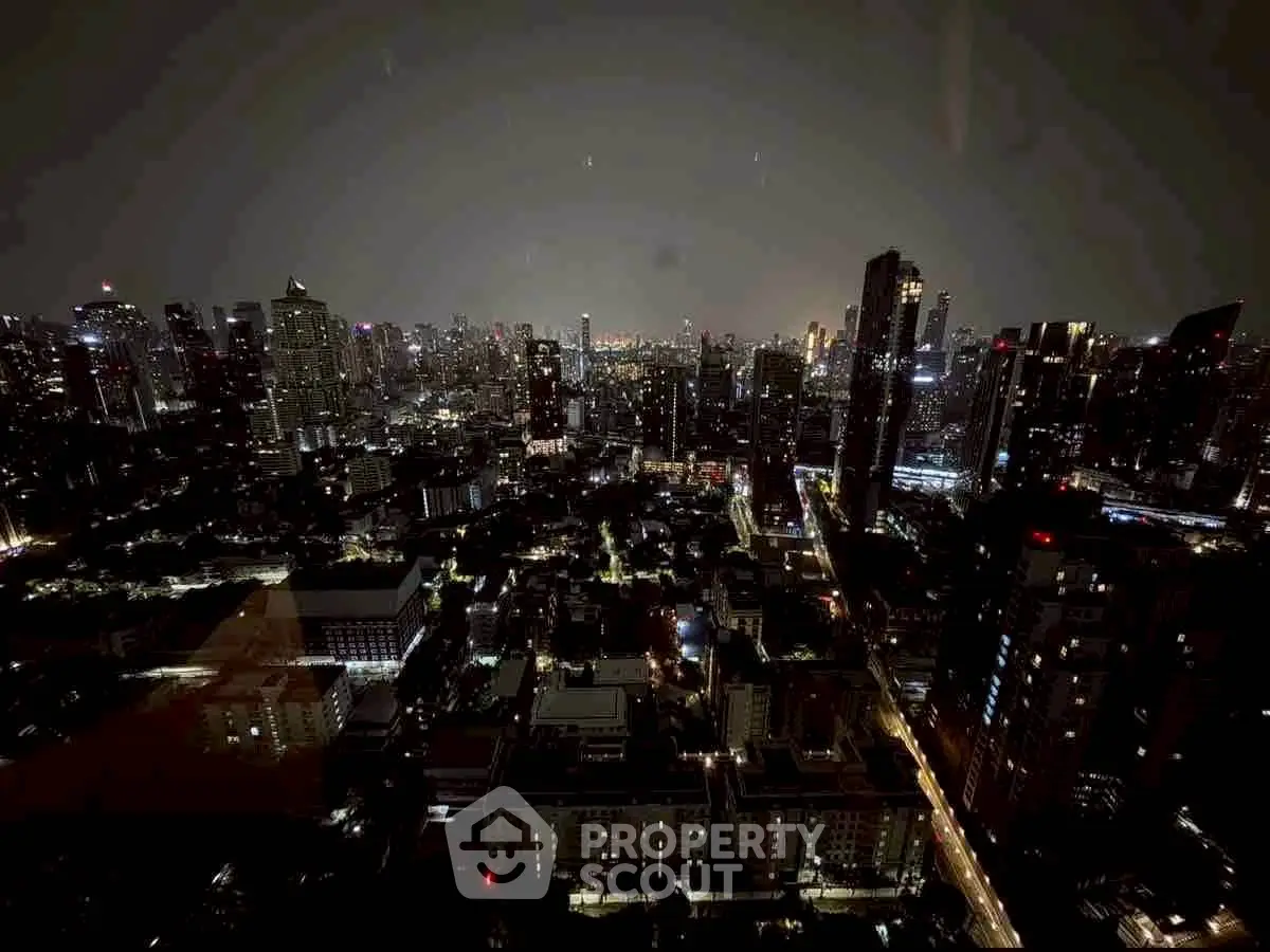 Stunning cityscape view from a high-rise apartment at night, showcasing vibrant urban lights and skyline.