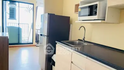 Modern kitchen with sleek appliances and balcony view in a stylish apartment.