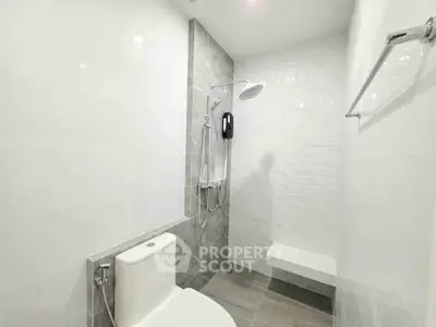 Modern bathroom with sleek shower and white tiles, perfect for a contemporary home.