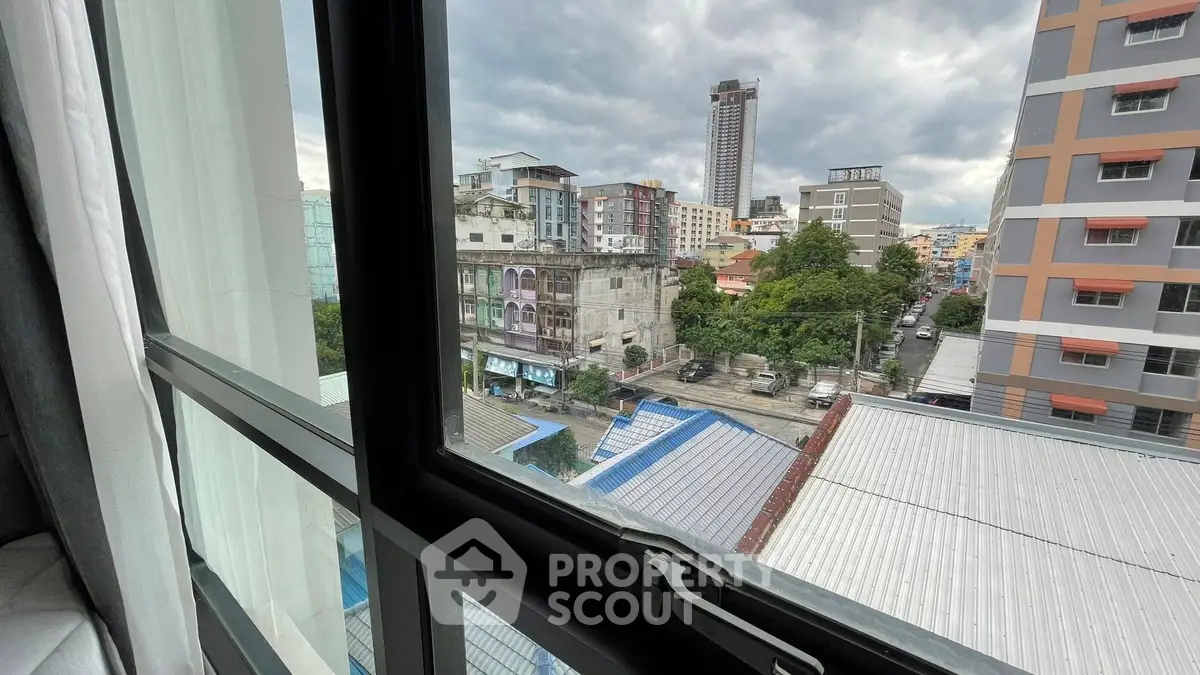Cityscape view from window showcasing urban buildings and skyline.