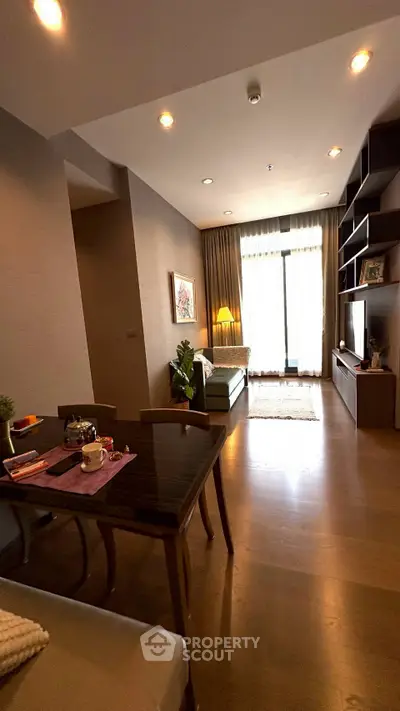 Modern living room with elegant decor and natural light, featuring a cozy seating area and stylish shelving.