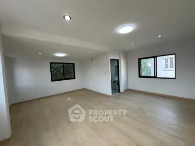Spacious and bright living room with large windows and modern lighting, perfect for family gatherings.