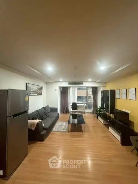 Spacious modern living room with sleek furniture and wooden flooring, perfect for comfortable living.
