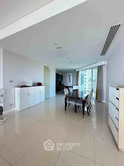 Spacious modern dining area with sleek furniture and large windows offering city views.