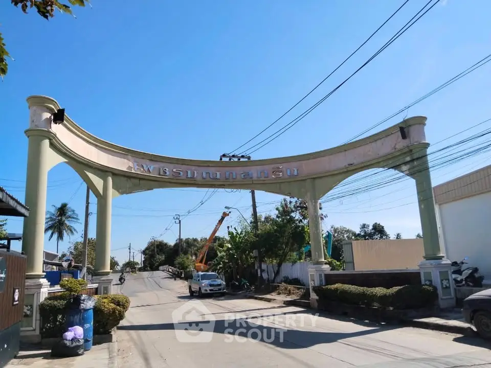 Grand entrance archway to a residential community with clear blue skies.