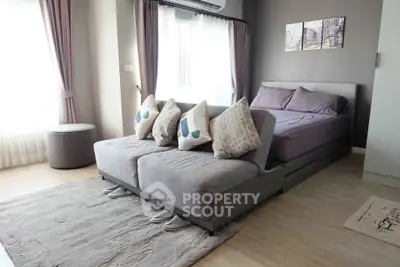 Modern bedroom with stylish decor and natural light, featuring a cozy bed and elegant furnishings.