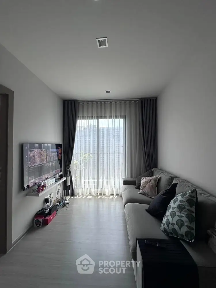 Modern living room with cozy sofa and large window with curtains