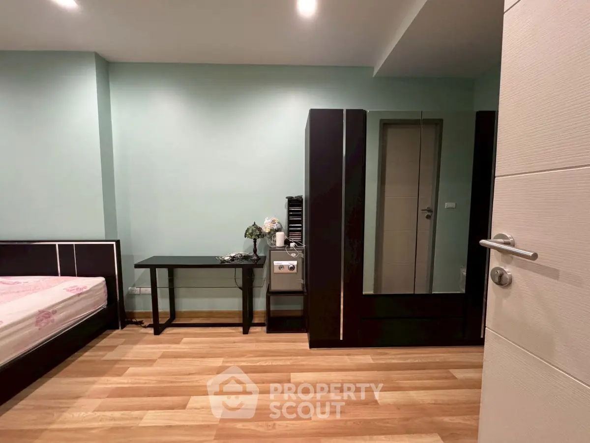 Spacious bedroom with modern furniture and wooden flooring, ideal for comfortable living.