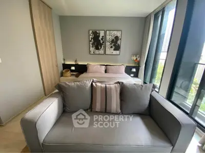 Modern bedroom with stylish decor and large windows offering natural light