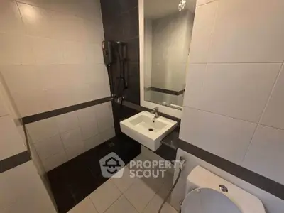 Modern bathroom with sleek design featuring a wall-mounted sink and shower area.