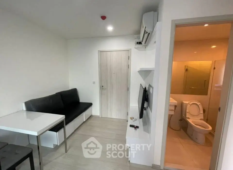 Modern compact apartment with sleek living area and adjacent bathroom