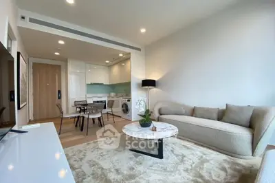 Modern living room with open kitchen, stylish furniture, and cozy ambiance