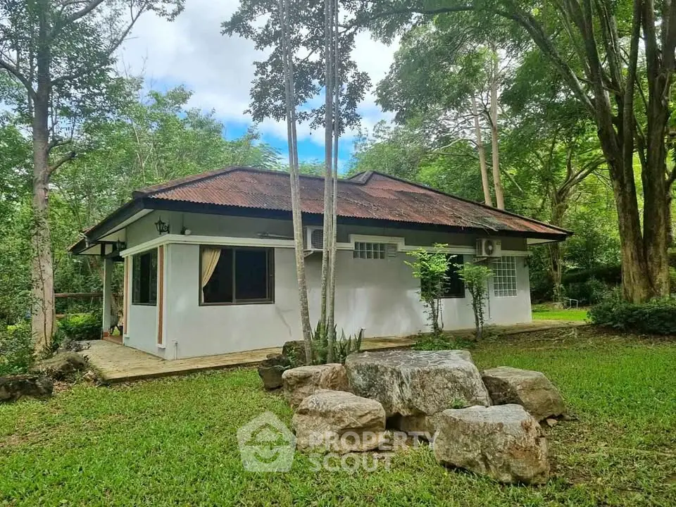 Charming countryside house surrounded by lush greenery and mature trees, perfect for nature lovers.