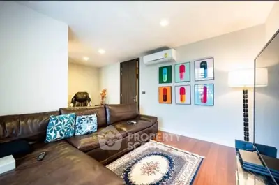 Stylish living room with leather sofa, modern decor, and air conditioning unit.