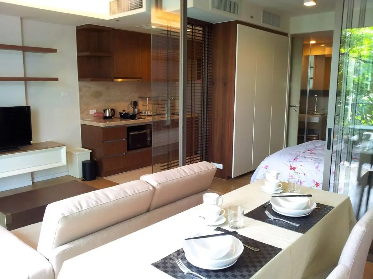 Modern open-plan living room with kitchen and dining area in a cozy apartment.