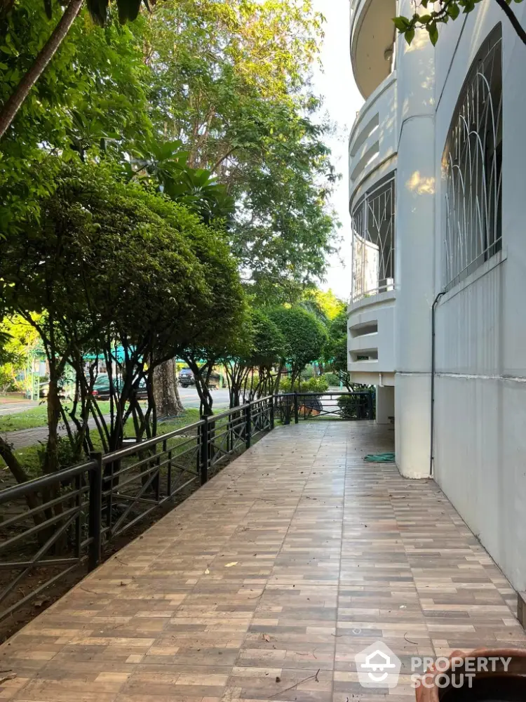 Charming exterior walkway with lush greenery and modern building facade