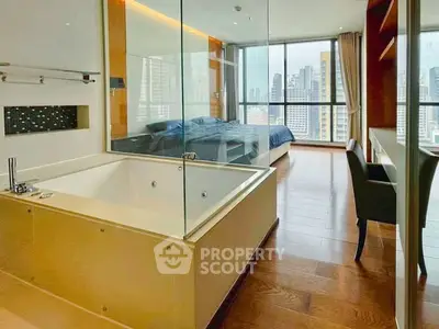 Luxurious bedroom with glass-enclosed bathtub and stunning city view