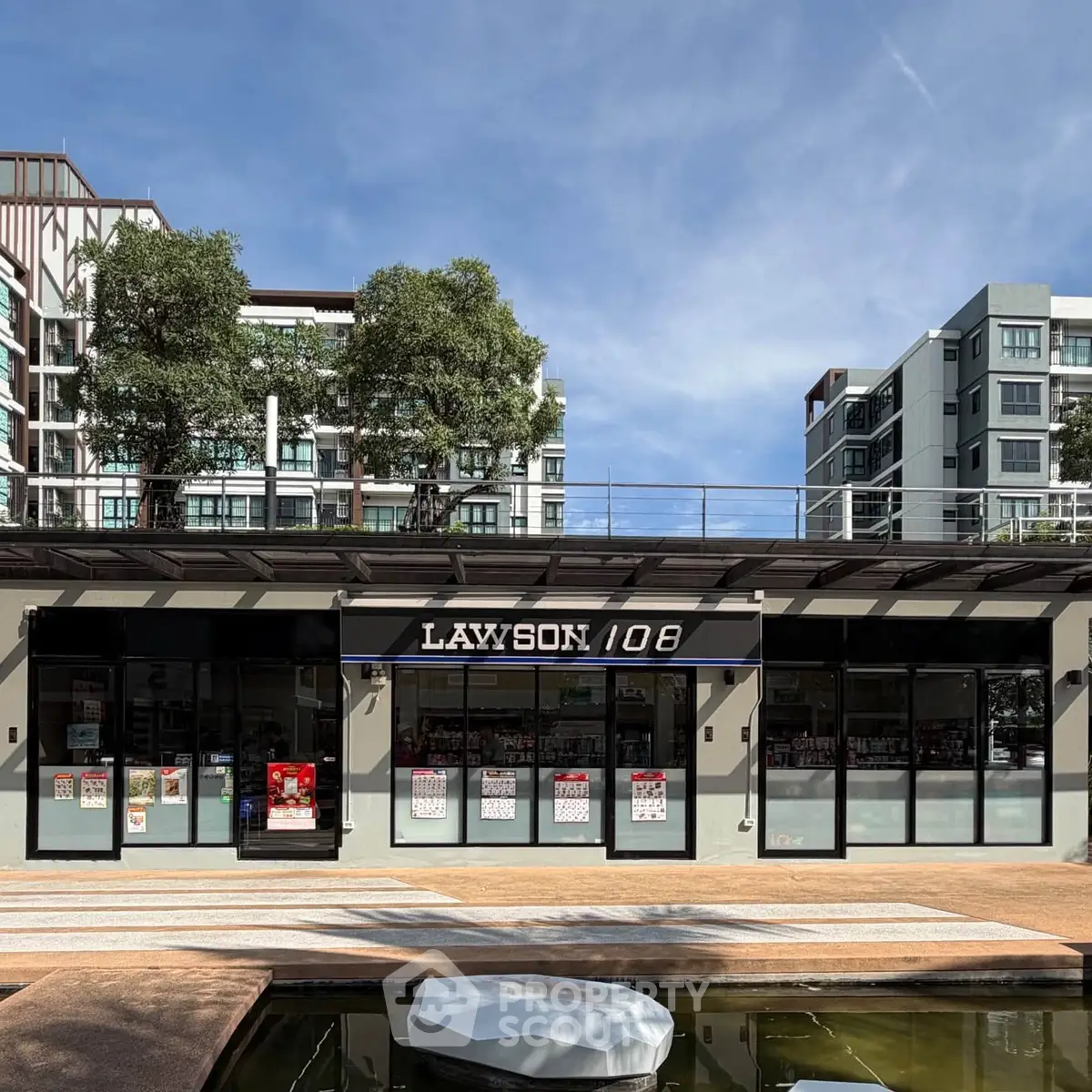 Modern apartment complex with retail space and landscaped surroundings.