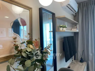 Modern living room with stylish decor and wall-mounted TV, featuring elegant shelving and air conditioning.