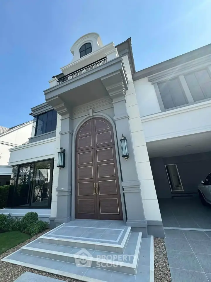 Stunning modern mansion with grand entrance and elegant architectural design.