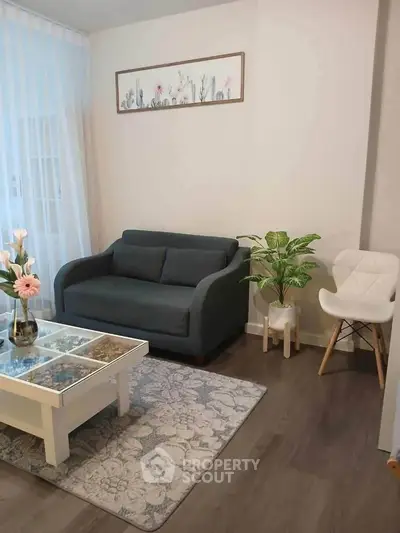 Charming living room with modern decor, featuring a cozy sofa, stylish chair, and elegant coffee table.