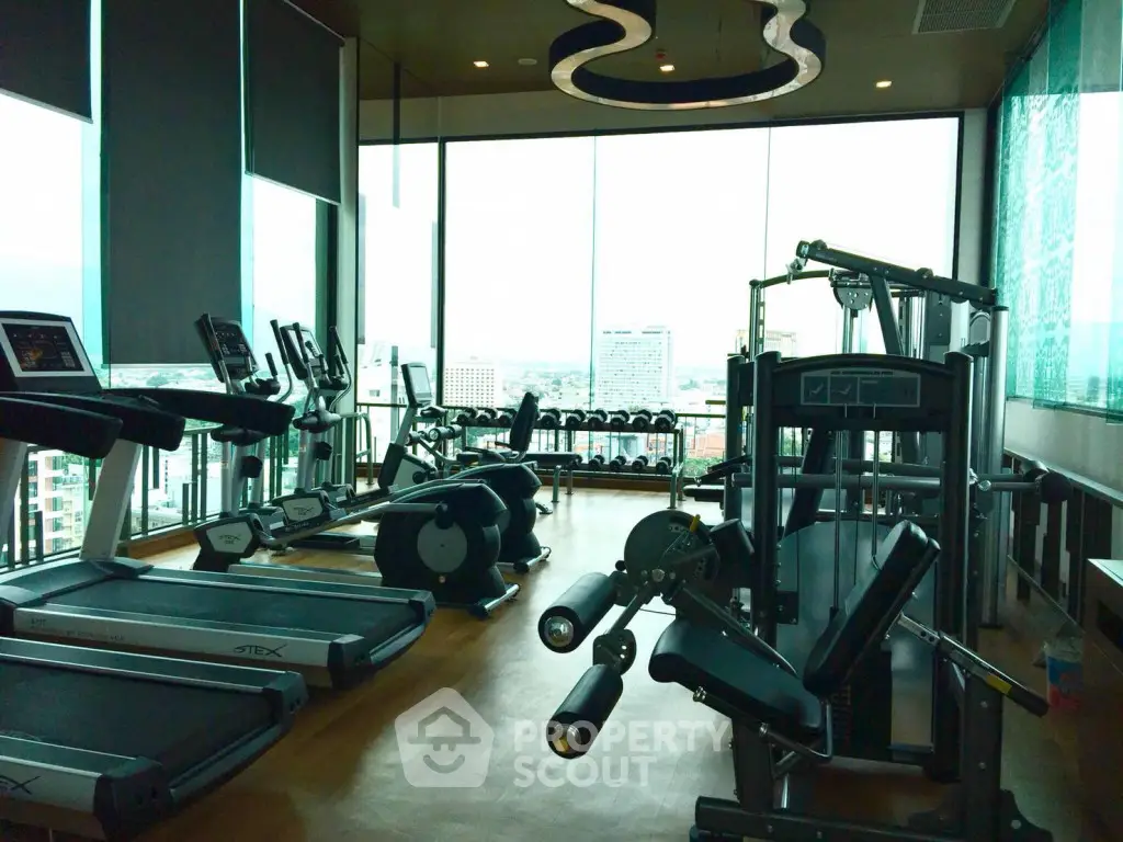 Luxurious high-rise gym with panoramic city views and modern fitness equipment.