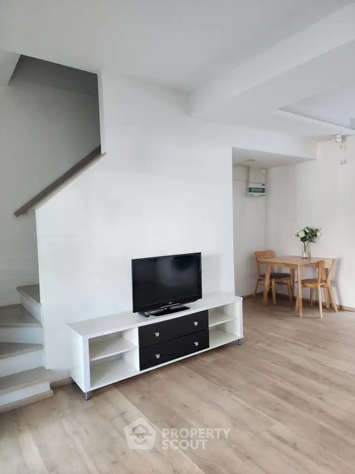 Modern living room with sleek TV stand and cozy dining area