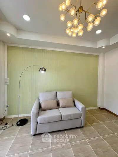 Stylish living room with modern chandelier and cozy sofa in a bright interior.