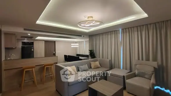 Modern living room with stylish lighting and cozy seating area in open-plan layout.