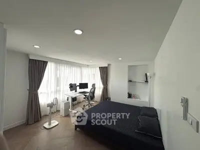 Modern bedroom with study area, featuring sleek design and ample natural light.