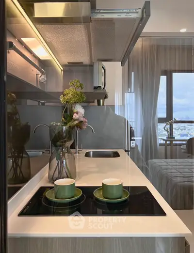 Modern kitchen with sleek design, featuring induction cooktop and elegant decor, perfect for contemporary living.