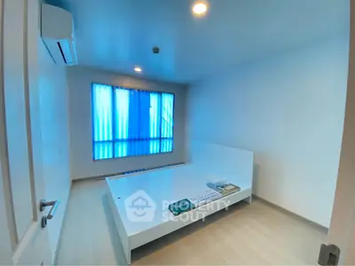Spacious minimalist bedroom with modern air conditioning and large window.