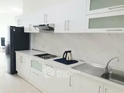 Modern kitchen with sleek white cabinets and marble backsplash