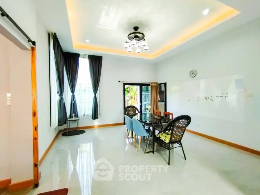 Spacious dining area with modern lighting and large windows in a stylish home.