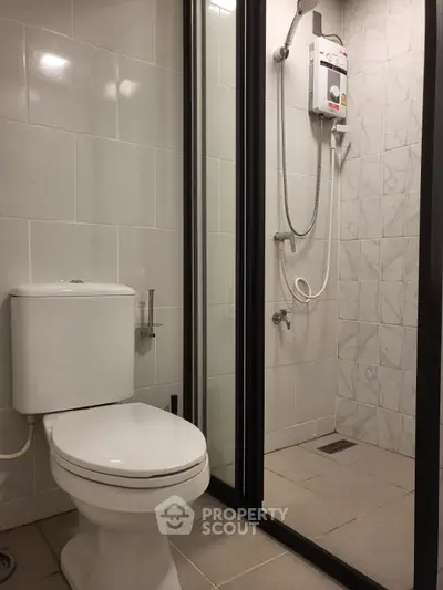 Modern bathroom with sleek shower and toilet in contemporary apartment.